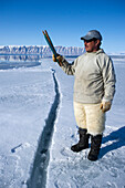 Inuit hunter line fishing at the floe edge for Arctic cod, sculpin and halibut near Herbert Island, Greenland, Denmark, Polar Regions