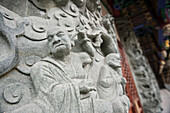 monch stabs into his ears - engraving carved into stone at Po Lin Monastry, Lantau Island, Hongkong, China, Asia