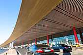 Schwarze Autos vor dem Flughafen, Taxi, gelbes Dach, rote Säulen, Internationaler Flughafen Peking, Terminal 3, Dach ist einem chinesischen Drachen nachempfunden, für Olympiade 2008 neu gebaut, Olympische Spiele 2008, Architekt Norman Foster, größtes Gebä