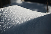 An organic-shaped mound of ice crystals half in sun, half shade, Whistler, British Columbia, Canada