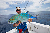 Fisherman holding a fresh caught Jackfish tuna, Tahiti
