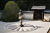 Japanese stone lantern in white gravel courtyard, Kyoto, Japan