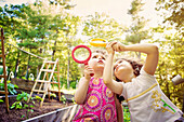 Girls examining caterpillar with magnifying glass