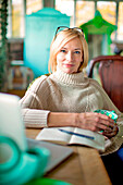 Caucasian entrepreneur drinking cup of coffee in shop