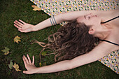 Woman laying on blanket in grass