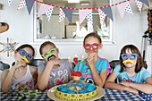 Children wearing disguises at birthday party