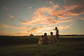 Caucasian family admiring corn fields at sunset