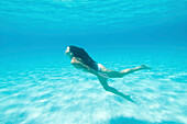 Underwater view of woman swimming in ocean