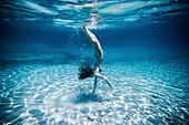 Unterwasseransicht einer Frau beim Schwimmen im Meer