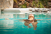 Hispanic woman swimming in pool