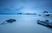 The cold blue sea bathes the beach still partially snowy. Myrland, Lofoten Islands, Northern Norway, Scandinavia, Arctic, Europe