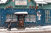 Mann bei Schneefall vor einer Bar, Argentiere, Frankreich