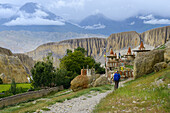 Zwei Wanderer, Trekker kurz vor Tangge, tibetische Ortschaft mit buddhistischem Kloster im Kali Gandaki Tal, dem tiefsten Tal der Welt, fruchtbare Felder gibt es in der Hochwueste nur durch ein ausgekluegeltes Bewaesserungssystem, Mustang, Nepal, Himalaya