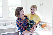 Mother holding son in kitchen