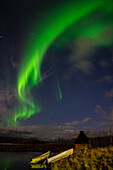 Aurora borealis over lake with boats and Kota, Kilpisjarvi, Northwest Finland, Lapland, Finland, Scandinavia, Europe