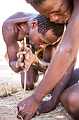 Men from the Himba tribe lighting a fire, North Namibia, Namibia, Africa
