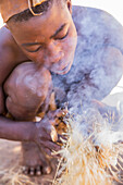 Himba man lighting a fire, North Namibia, Namibia, Africa