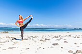 Strong athletic female in a yoga pose in Kuta, Lombok, Indonesia