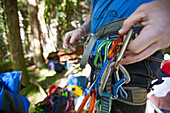 A rock climber clips in a carabiner quickdraw on to his harness.