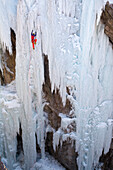 A man ice climbing a frozen waterfall in the Ouray Ice Park, Ouray, Colorado.