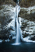 Icy waters of Horestail Creek flow over Horestail Falls in the winter, Columbia River Gorge National Scenic Area, Oregon.