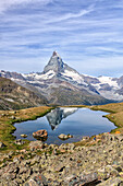 Hikers admire the Matterhorn reflected in Lake Stellisee, Zermatt, Canton of Valais, Pennine Alps, Swiss Alps, Switzerland, Europe