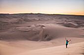 Tourist in the desert at sunset at Huacachina, Ica Region, Peru, South America