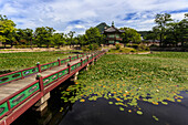 Hyangwonjeong pavilion and Chwihyanggyo bridge over water lily filled lake in summer, Gyeongbokgung Palace, Seoul, South Korea, Asia