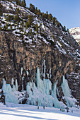 Skiers underneath the frozen waterfall, Hidden Valley ski area, Lagazuoi, Armentarola 101, Ski piste, Dolomites, UNESCO World Heritage Site, South Tyrol, Italy, Europe