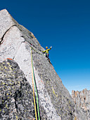 Caucasian climber waving on mountainside