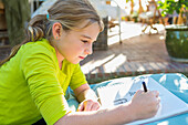 Caucasian girl drawing outdoors