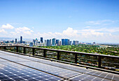 Solar panels and Manila cityscape under blue sky, Philippines