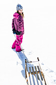 Girl pulling her sledge, Pfronten, Allgaeu, Bavaria, Germany