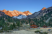 Almhütten mit Kleinschober, Debantgrat, Ralfkopf und Glödis im Alpenglühen im Hintergrund, Debanttal, Schobergruppe, Hohe Tauern, Nationalpark Hohe Tauern, Osttirol, Tirol, Österreich