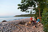 Lagerfeuer am Strand, Mutter und Kinder grillen Maiskolben am Lagerfeuer, Abenteuer, dänische Ostseeinsel, Ostsee, MR, Insel Bornholm, bei Gudhjem, Dänemark, Europa