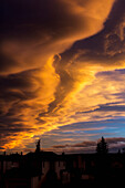 Dramatic colourful clouds at sunset with interesting formations and some blue sky with houses in a neighbourhood, Calgary, Alberta, Canada