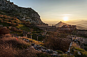 Ruins of stone buildings and walls at sunset, Corinth, Greece