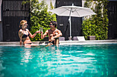 Couple on holiday, having drinks by a swimming pool, Santiago, Chile, South America