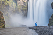 Tourist taking a photo of Skogafoss Waterfall, Skogar, South Region Sudurland, Iceland, Polar Regions