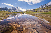 The snowy peaks are reflected in the clear waters of Lake Piz, La Margna, Fedoz Valley, Engadine, Switzerland, Europe
