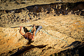 Woman climbing at Montserrat, in a warm afternoon, Spain.