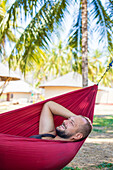 Man Relaxing In Hammock