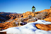 A man riding his mountain bike in the snow outside of St. George, Utah.