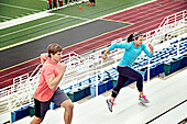 Caucasian athletes running up bleachers