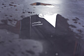 'Puddle with reflection of sign reading ''massage'''