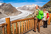 couple de randonneurs seniors admirant le panorama sur le glacier d'aletsch, site des alpes suisses classe au patrimoine mondial de l'unesco, bettmeralp, canton du valais, suisse