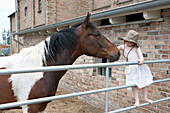 Girl embracing horse at farm