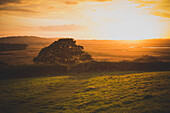 Scenic view of green landscape against sky during sunset