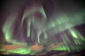 The shapes of green light of the Aurora Borealis color the sky, Lyngen Alps, Troms, Lapland, Norway, Scandinavia, Europe