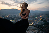 Caucasian woman on hilltop near cityscape view